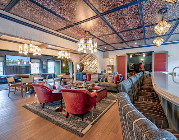A living room with a long couch and a table with chairs.