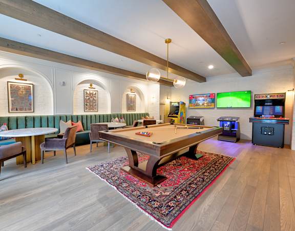 A room with a pool table and a foosball table.