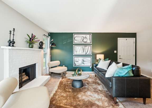 A living room with a fireplace, a couch, and a rug. at Woodcreek Apartments, North Carolina