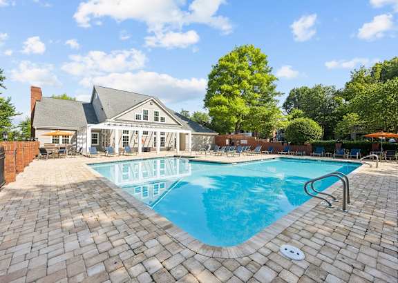 a swimming pool with a house in the background