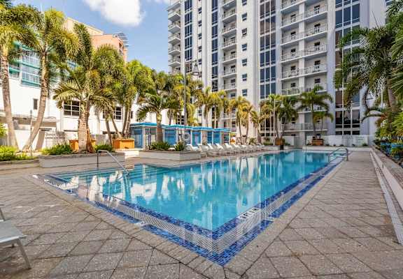a large swimming pool with palm trees and a building in the background at Paramount on Lake Eola, Orlando, FL
