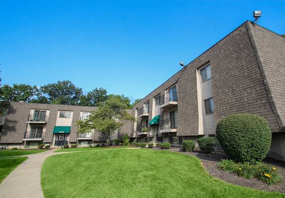 an apartment building with a green lawn and a sidewalk  at Village East, Franklin, Ohio