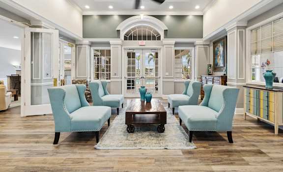 a living room with blue chairs and a table at Promenade at Reflection Lakes, Florida