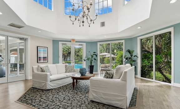 a living room with two white couches and a rug at Cypress Shores, Coconut Creek