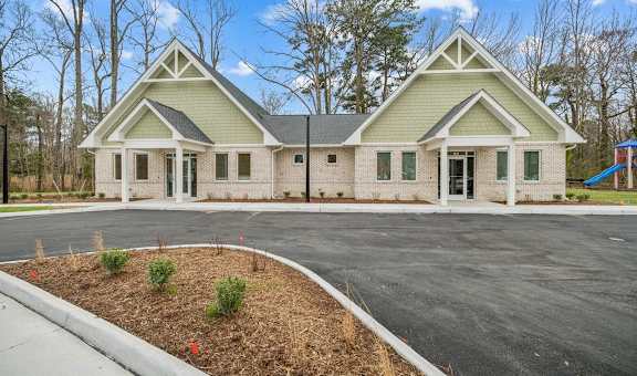 A two-story house with a green roof and white trim. at The Courtyards of Chanticleer Apartments, Virginia