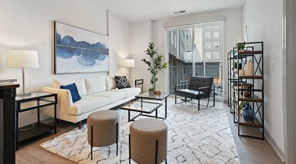 A modern living room with a white sofa, a grey armchair, and a coffee table.