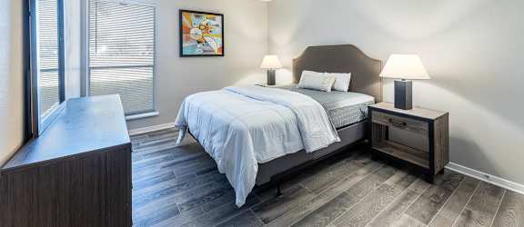 A bedroom with a bed, nightstand, and a ceiling fan.