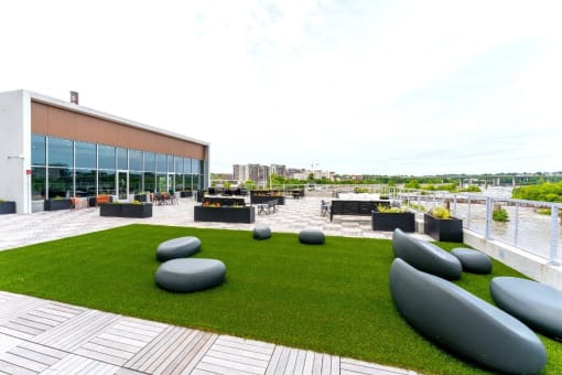 a roof terrace with lawn furniture and a building in the background