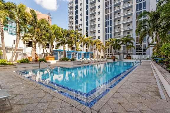 a large swimming pool with palm trees and a building in the background at Paramount on Lake Eola, Orlando