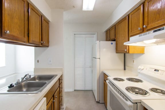 a kitchen with white appliances and wooden cabinets and a white refrigerator