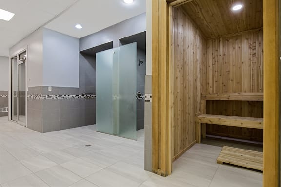 A bathroom with a wooden wall and a glass door.