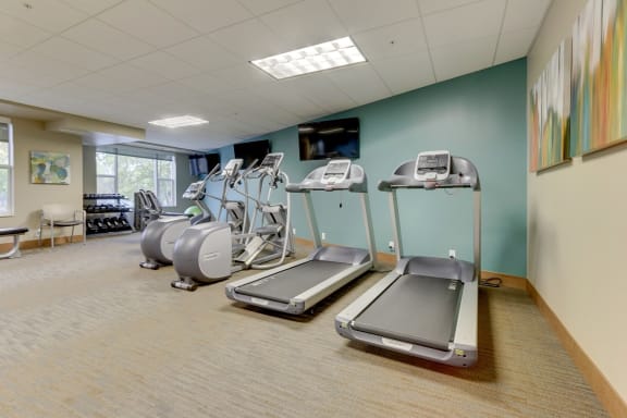 a gym with cardio equipment and exercise machines at The Legends at Silver Lake Village 55+ Apartments, St. Anthony, Minnesota