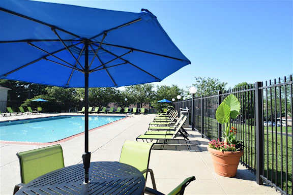 a swimming pool with tables and chairs with umbrellas at Chinoe Creek Apartments, Lexington, KY, 40502