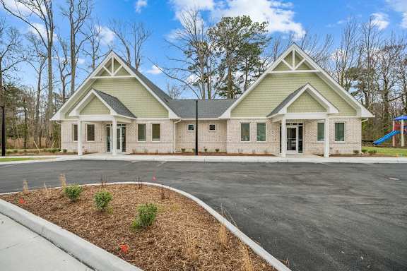 A two-story house with a green roof and white trim.