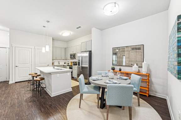 A kitchen with a dining table and chairs.