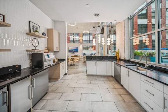 A modern kitchen with a black countertop and white cabinets. at The Locks, Richmond, 23219