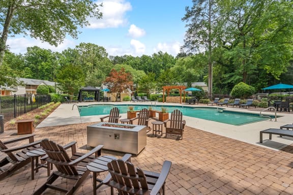 a swimming pool with patio furniture and a fire pit