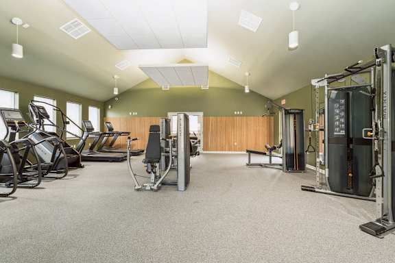 A gym with a variety of equipment including treadmills, weights, and exercise machines.