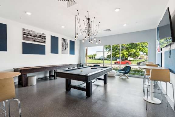 A room with a pool table and a tv.