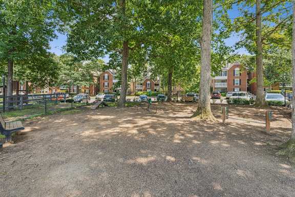A park with a dirt ground and trees.