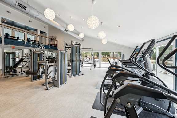 A gym with treadmills, elliptical machines, and other cardio equipment.