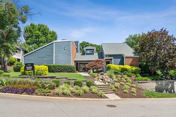 A house with a green lawn and a sign at Woodcreek Apartments, North Carolina