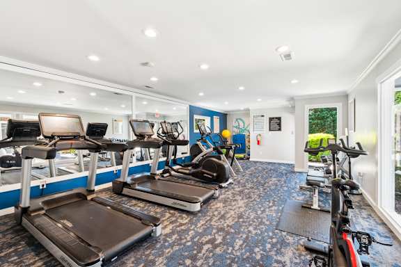 A gym with treadmills, exercise bikes, and elliptical machines. at Woodcreek Apartments, North Carolina