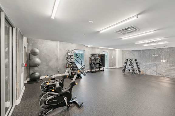 A gym with exercise equipment and a mirror on the wall.