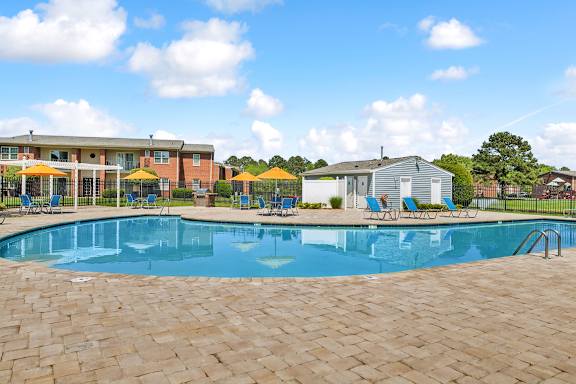 A large swimming pool surrounded by a brick patio.