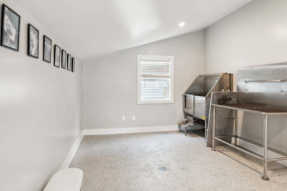 A room with a bed, a window, and pictures on the wall.