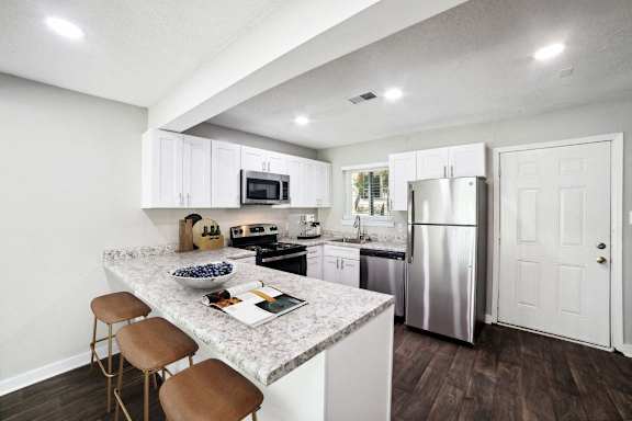 a kitchen with white cabinets and stainless steel appliances at Lakecrest Apartments, PRG Real Estate Management, Greenville, South Carolina