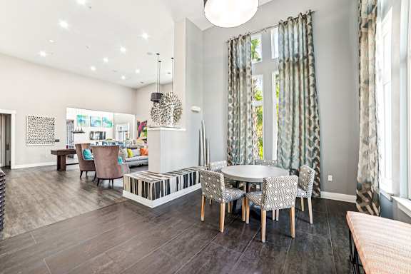 A modern dining room with a glass table and chairs.