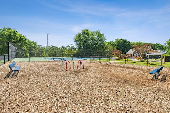 A playground with a swing set and a slide. at Woodcreek Apartments, North Carolina