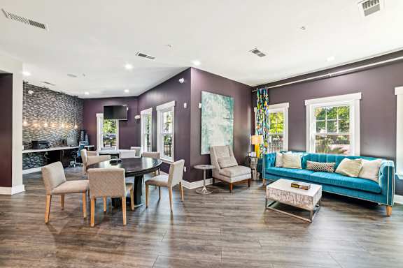 A living room with a purple wall and a blue couch.