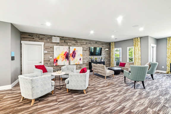 A living room with a grey sofa, red chair, and a painting on the wall.
