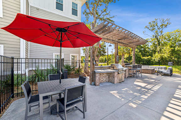 A red umbrella is on a patio table.