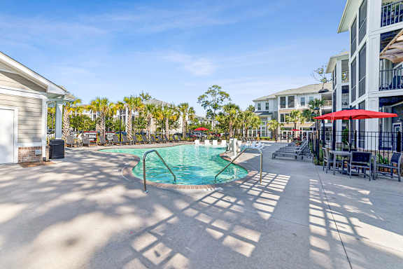 A pool area with a small pool and sun loungers.