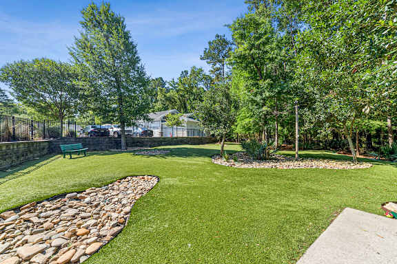 A green lawn with a stone pathway and a bench.
