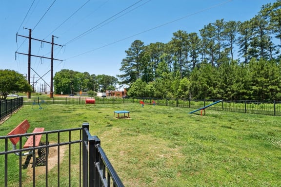 a fenced in backyard with a dog park and a picnic table at The Courtyards of Chanticleer, Virginia Beach, VA
