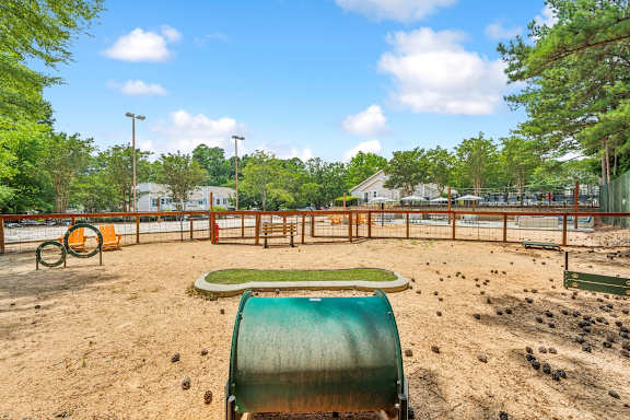 A playground with a green slide and orange swings.