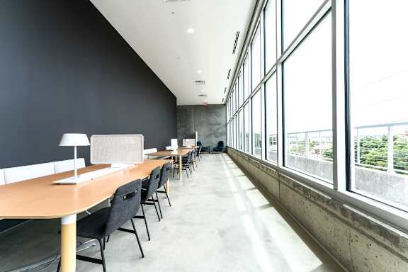 a long room with desks and chairs and large windows at South Falls Tower, Richmond, VA, 23224