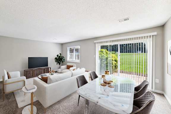 a living room with white couches and a glass table at Lakecrest Apartments, PRG Real Estate Management, Greenville, South Carolina