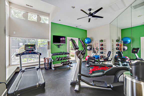 A room with a treadmill and exercise equipment.
