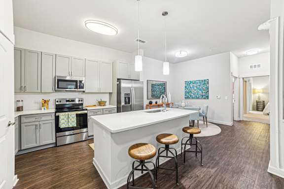 A kitchen with a white island and stools.