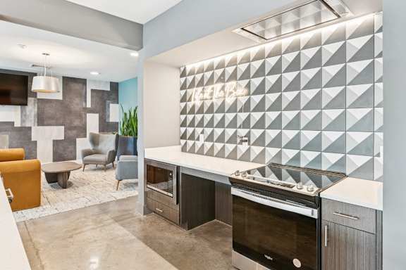 A modern kitchen with a large island and a backsplash of triangles.