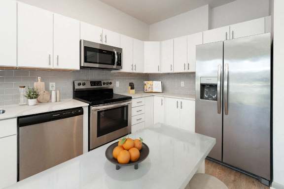 a kitchen with stainless steel appliances and white cabinets