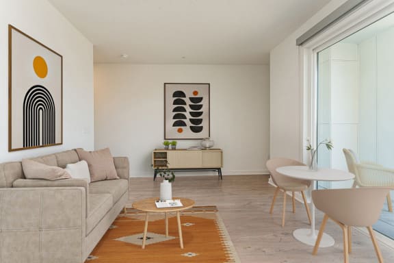 a living room with a couch table and chairs and a painting on the wall