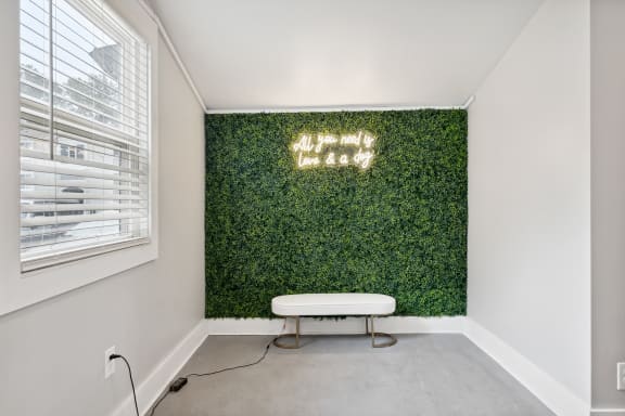 a living wall with a white bench in front of it