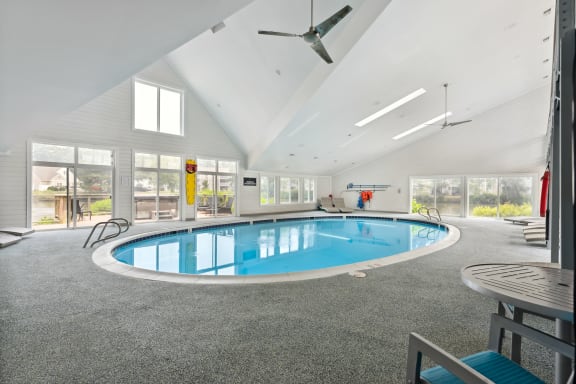 a large indoor swimming pool with a ceiling fan