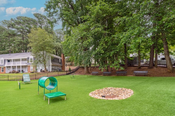 a large grassy area with a fire pit and benches at Lake Johnson Mews, North Carolina